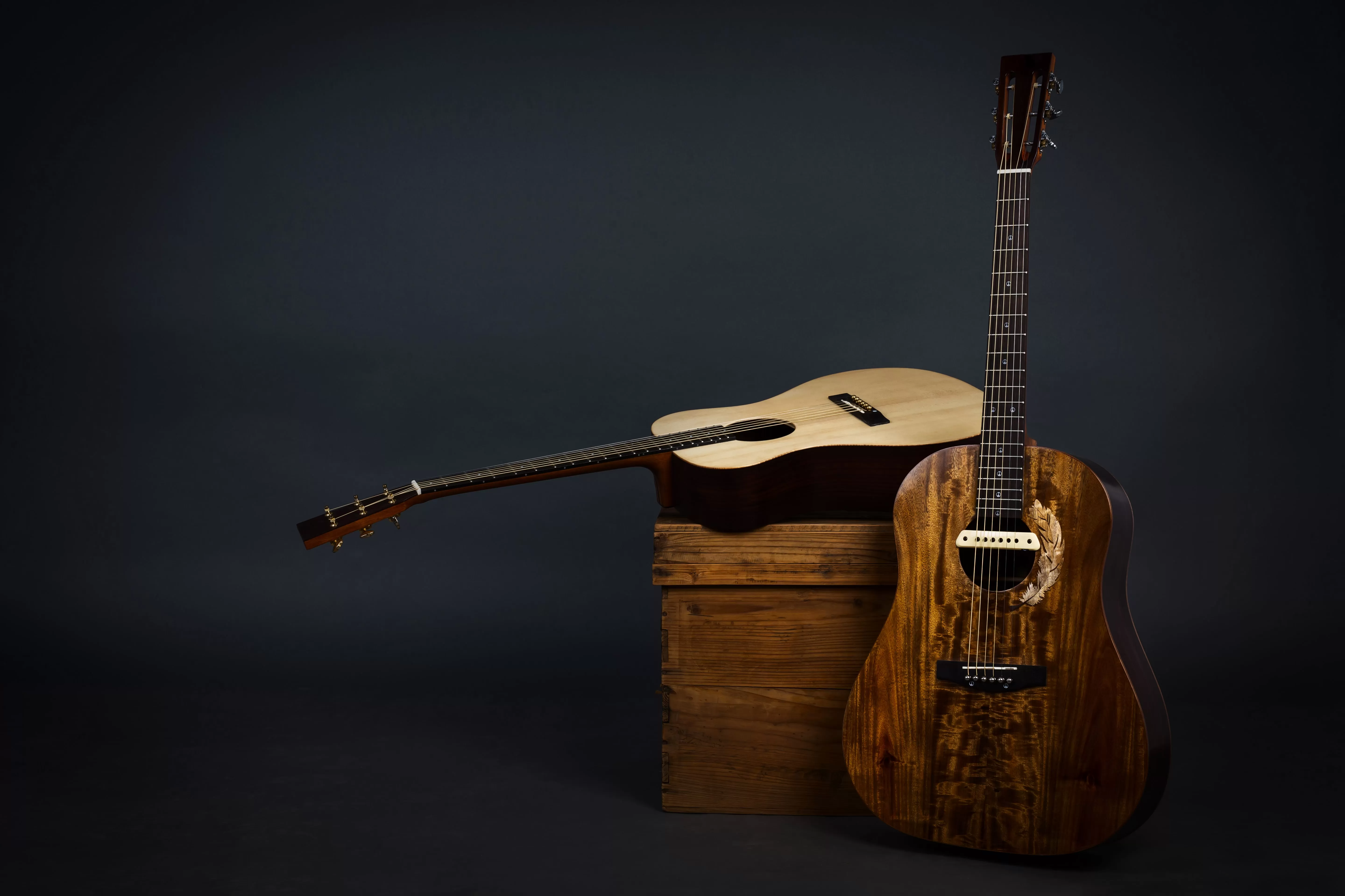 acoustic-guitar-chair-close-up-brown-guitar-black-wall-min